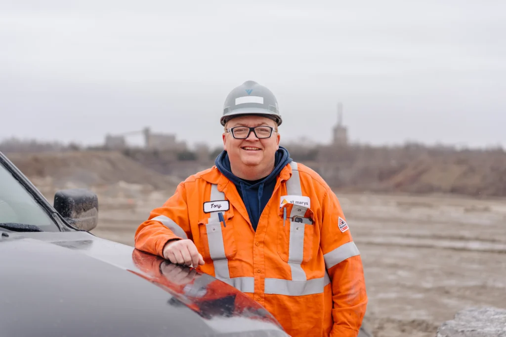 St Marys Community Relations - smiling St Marys Cement team member in orange coveralls and hard hat at the quarry