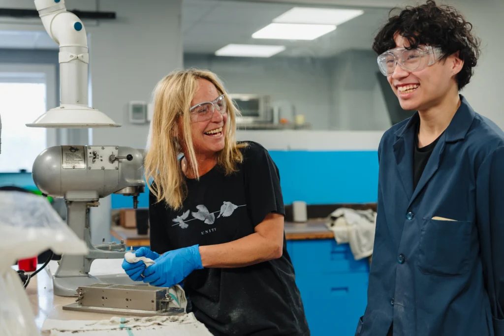 Badger Alternative Fuels - two lab team members in safety glasses smiling while working in a quality lab