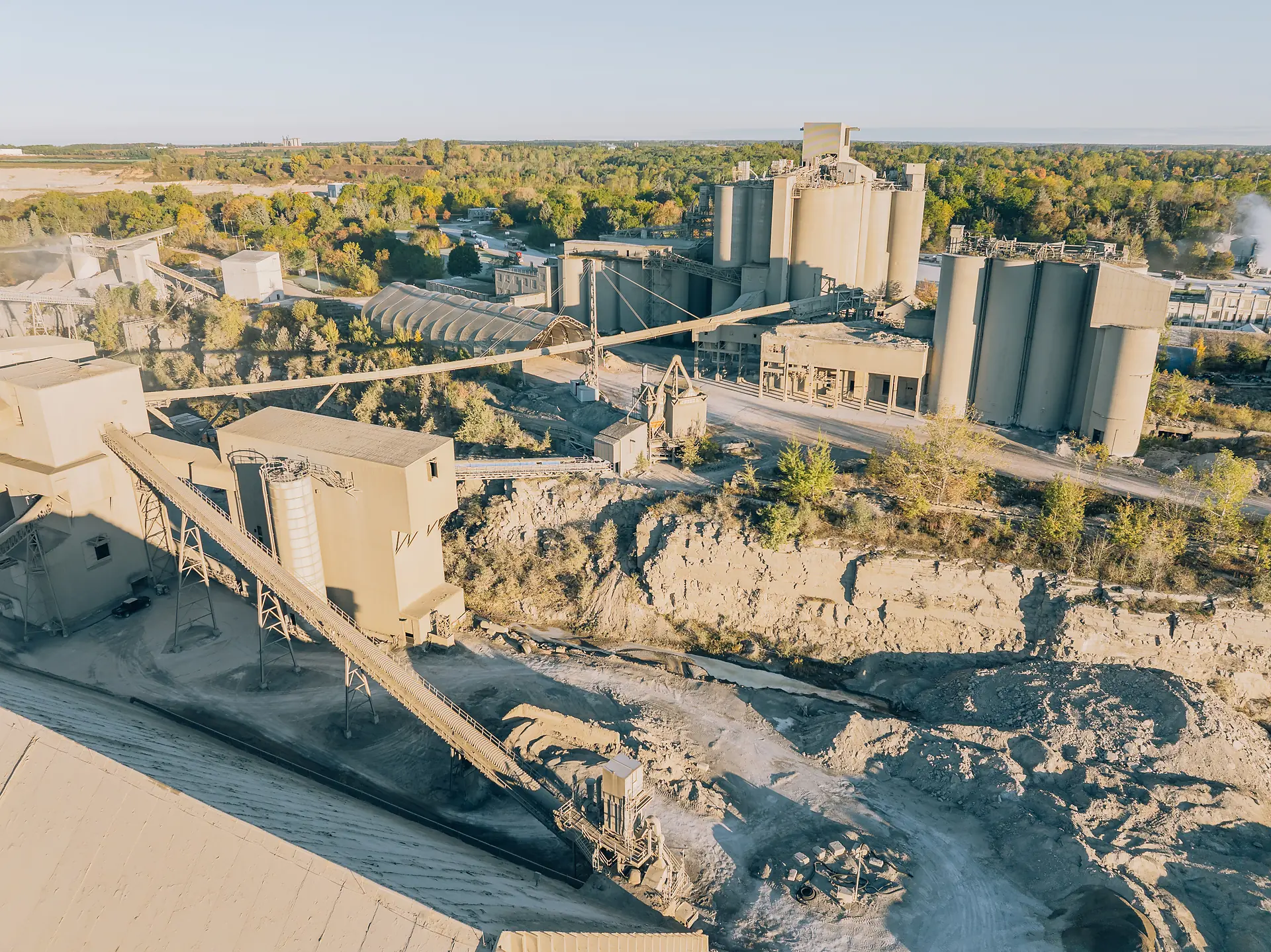 Type I/II Cement - aerial view of the cement plant silos and conveyors above a quarry face