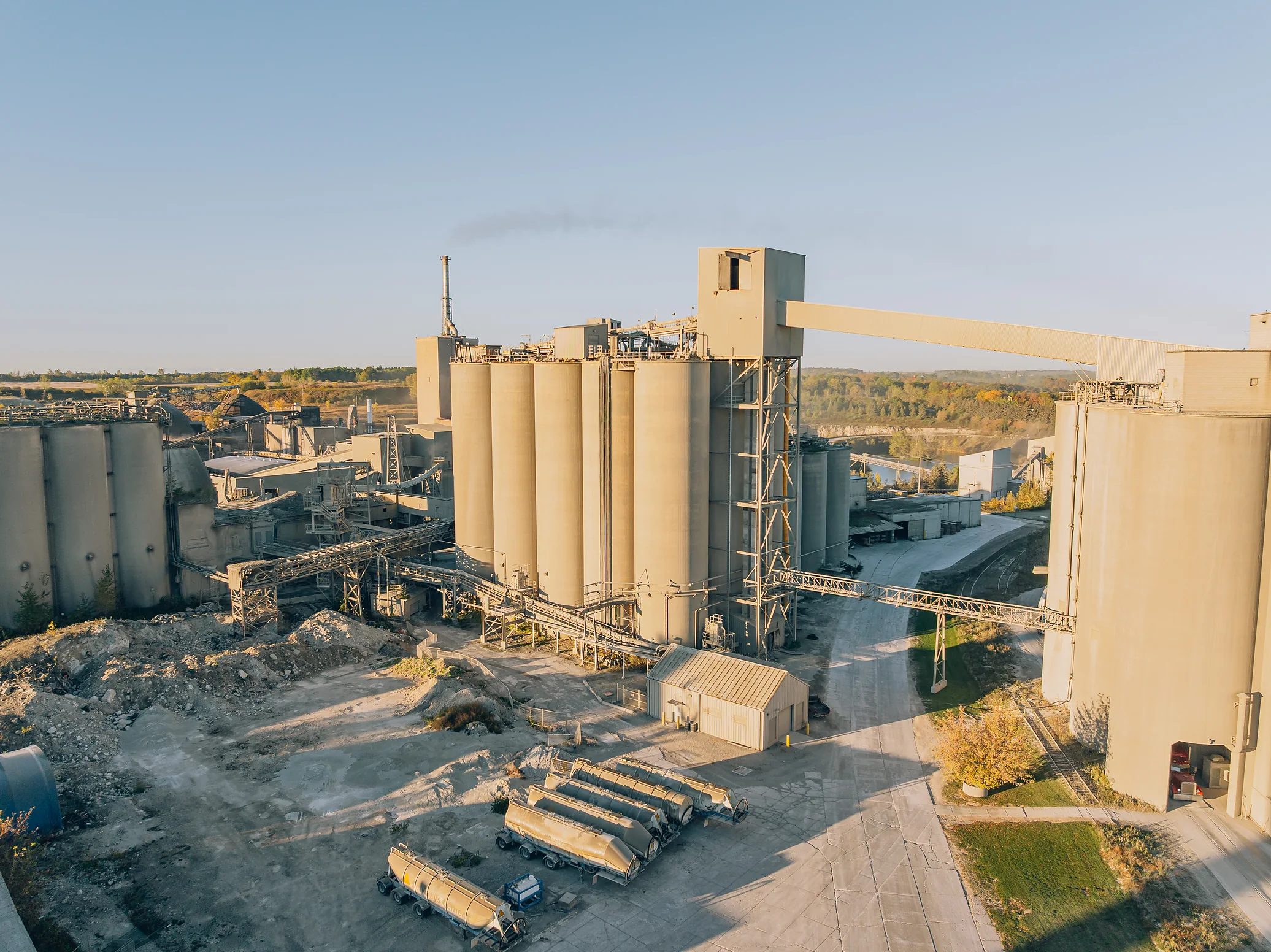 Type IP Blended Silica Fume Cement - cement silos and plant buildings with trailers parked in the yard on a clear day