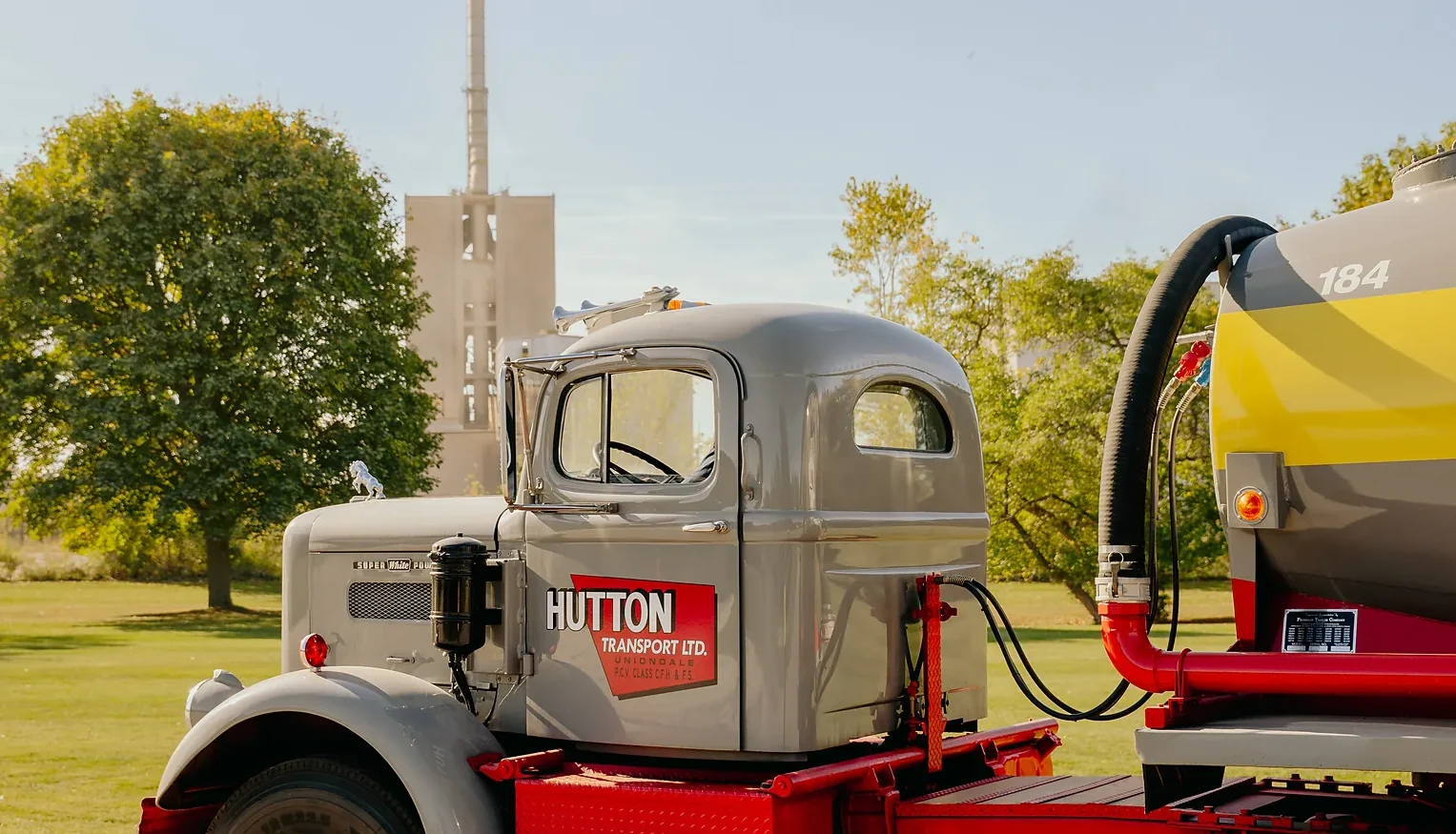Type GUL Portland Limestone Cement - vintage Hutton Transport tractor unit with a yellow tanker, plant stack and trees behind