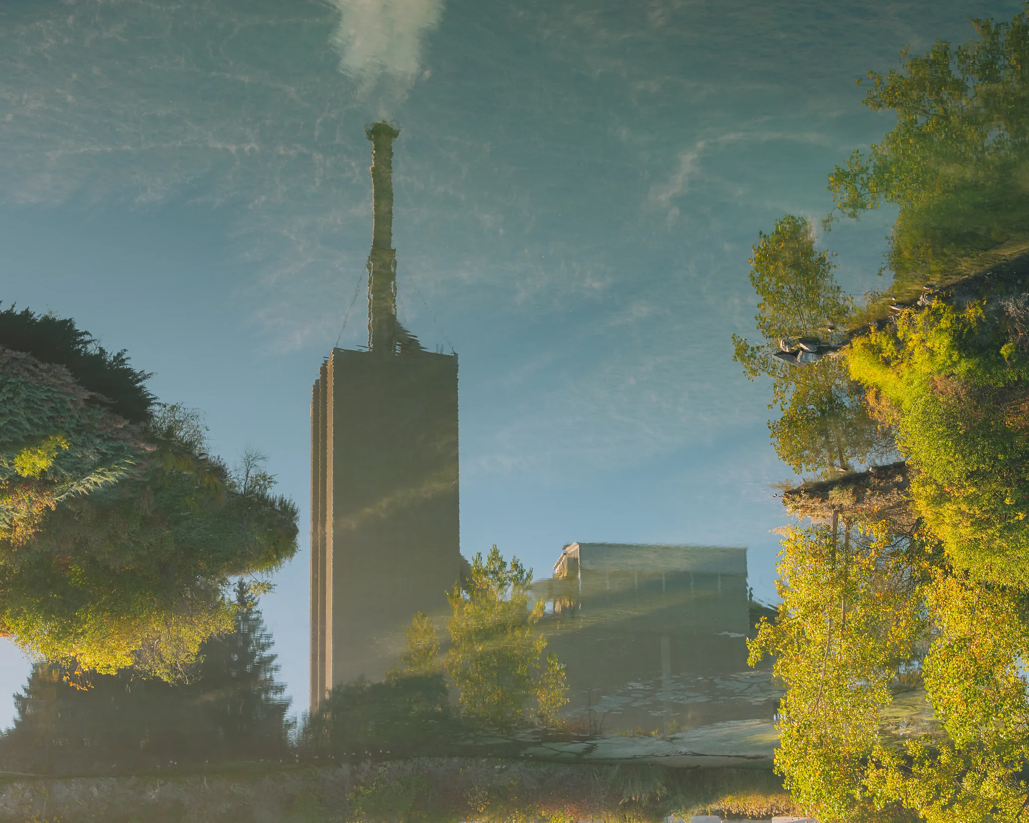 Type N Mortar Cement - upside-down reflection of the cement plant stack and trees in still pond water