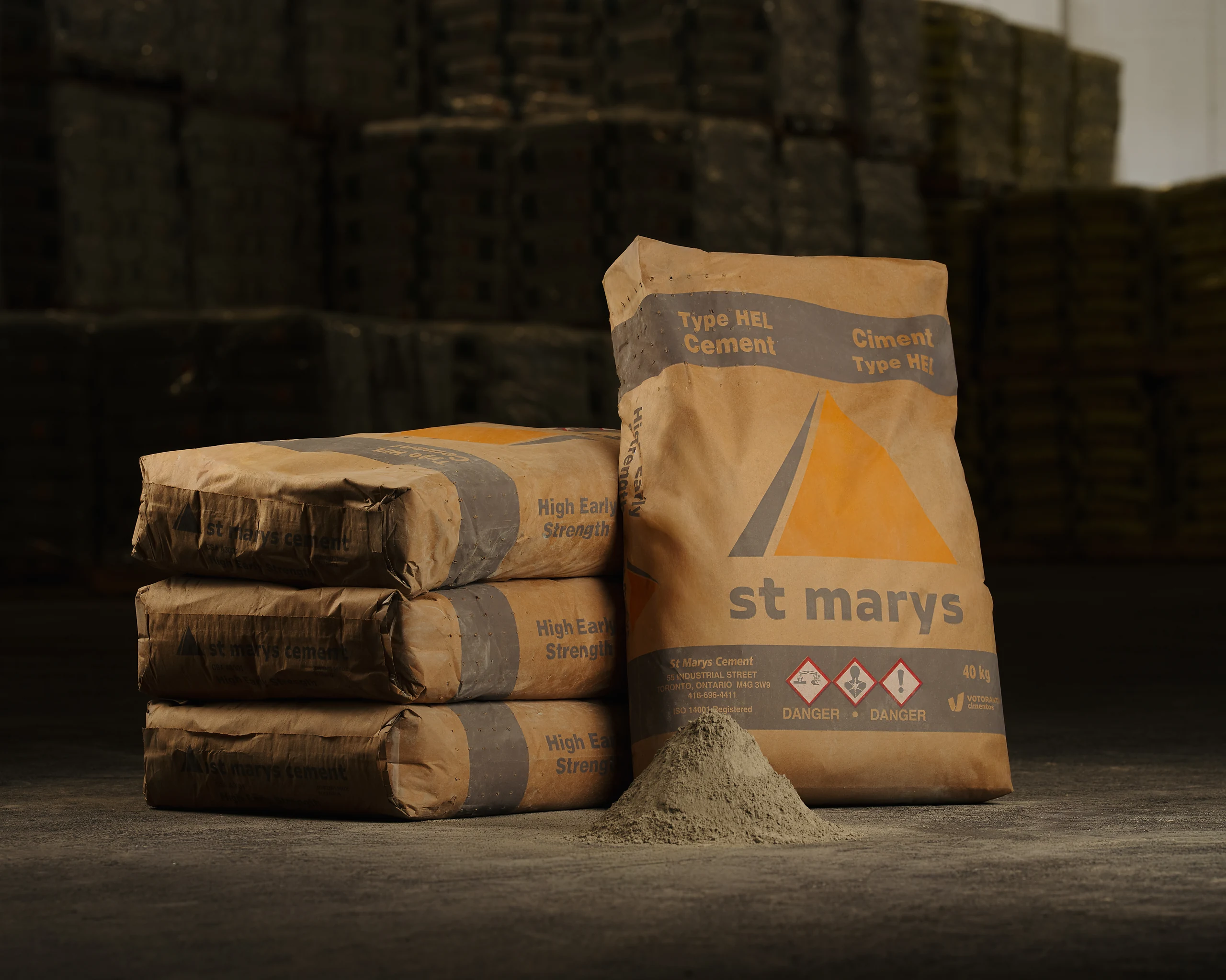 Cement Type IL(HE) - St Marys Type HEL high early cement bags in kraft paper stacked beside a pile of cement powder