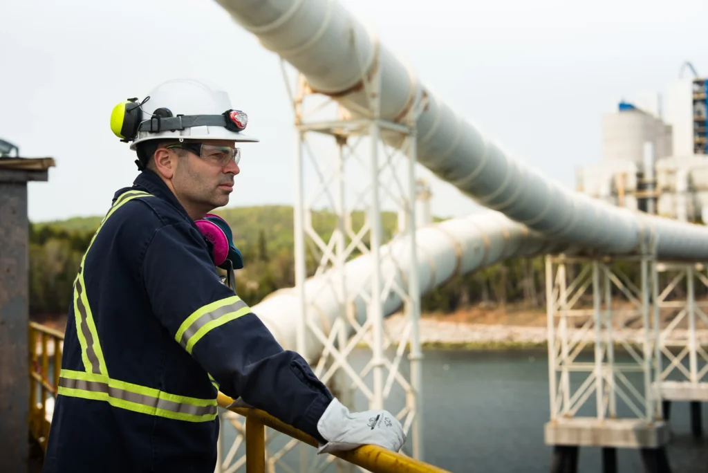 McInnis Cement Plant - McInnis team member in a hard hat at a railing beside the dock conveyors