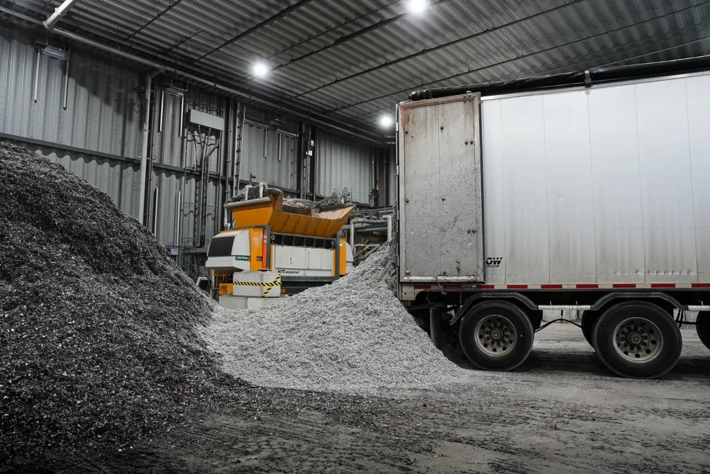 Cement Sustainability Commitments - shredded alternative fuel beside a shredder and delivery trailer in a storage building