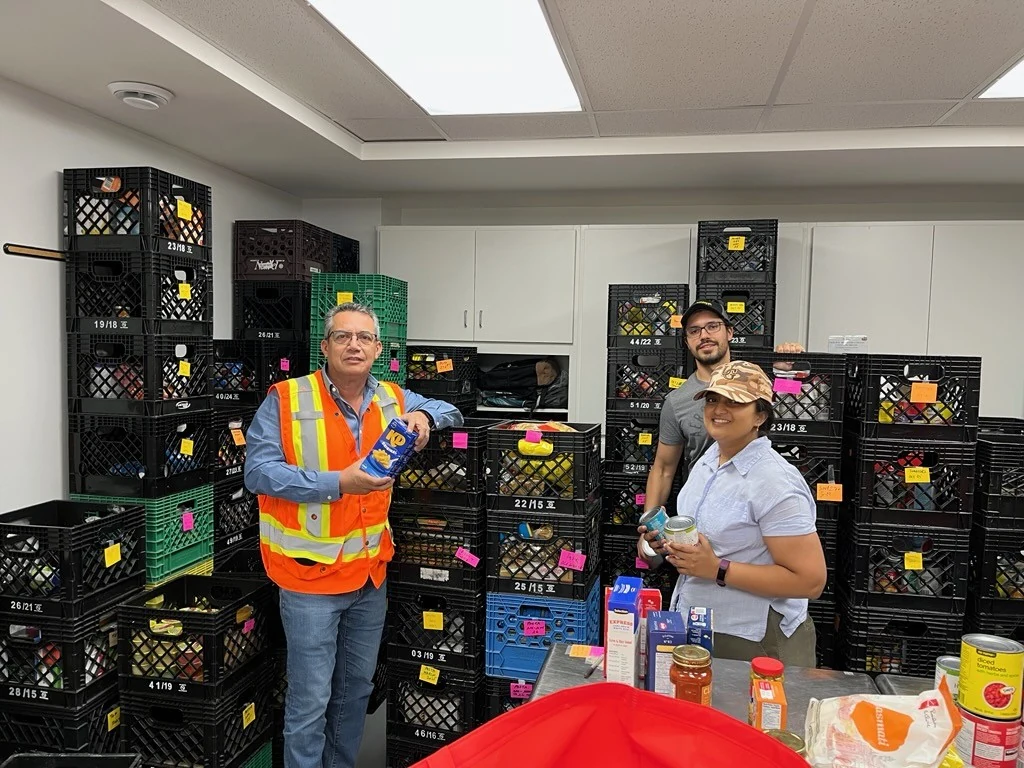 St Marys Cement Community Involvement - employees in hi-vis sorting donations among stacked milk crates at a food bank