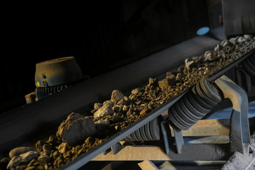 Detroit Cement Plant - raw material moving along a conveyor belt in low light